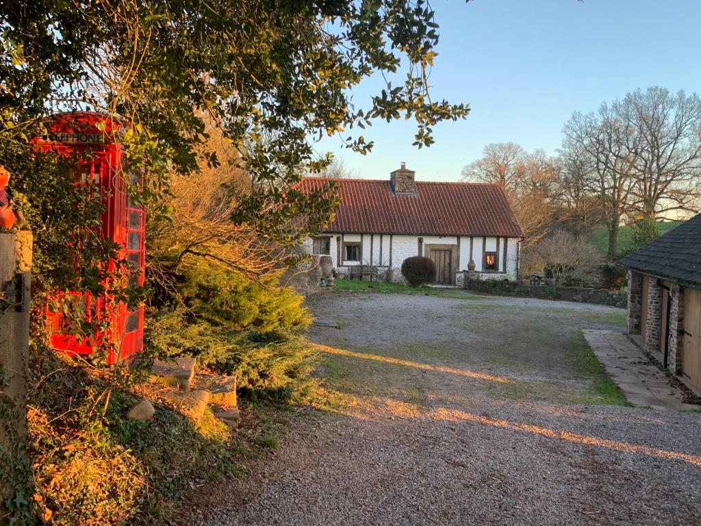RaglanMedieval Cottage in rural Monmouthshire.的前面有红墙的房子