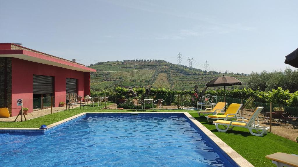 拉梅戈Quinta dos Padrinhos - Suites in the Heart of the Douro的一个带椅子的游泳池以及一座房子