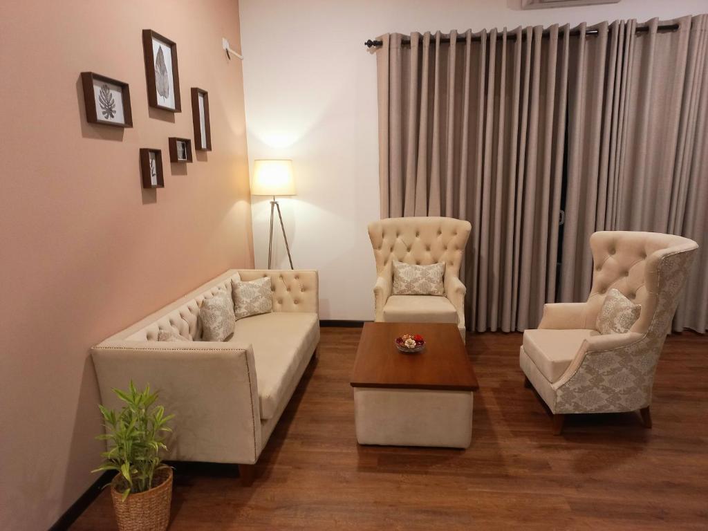 库鲁内格勒NINETY-NINE APARTMENTS的客厅配有两把椅子、一张沙发和一张桌子
