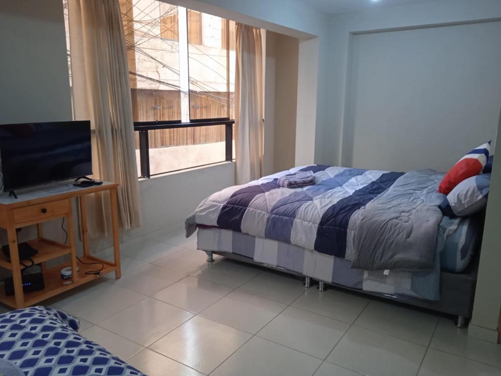 库斯科La casa de Chepita的一间卧室配有一张床、一台电视和一个窗口