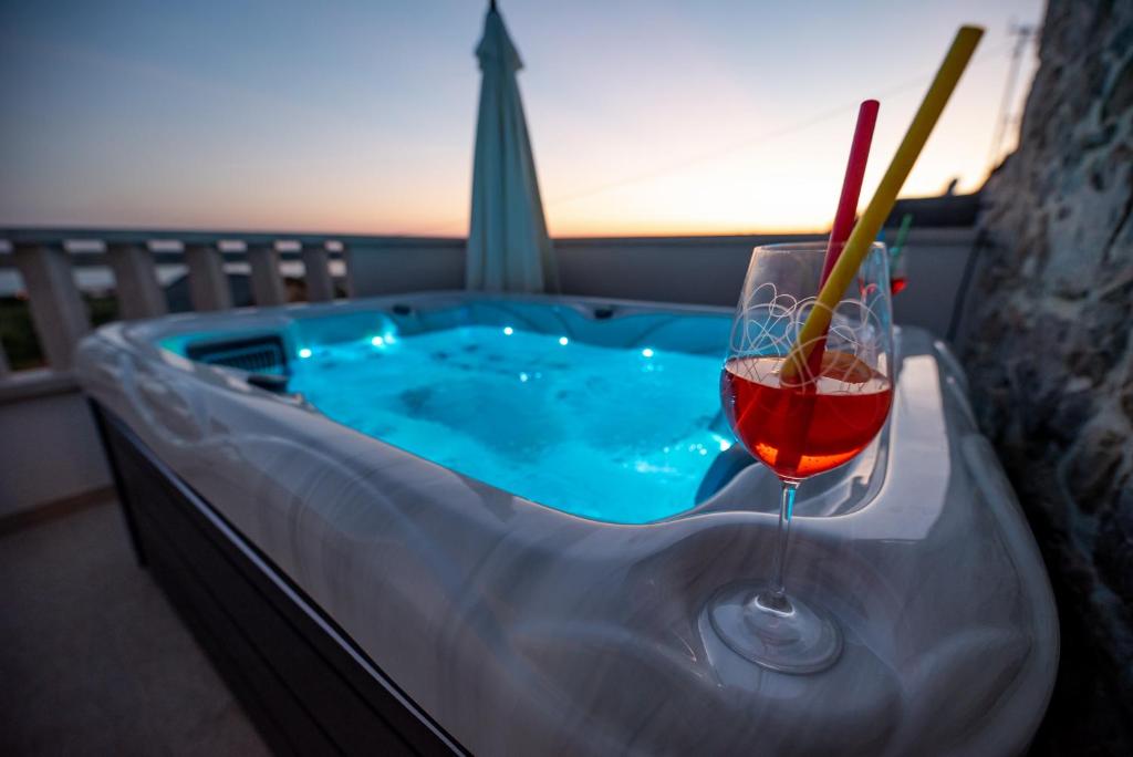 拉扎纳茨Didov dvor的热水浴池,提供一杯葡萄酒和饮料