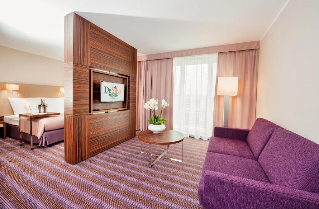 奥普尔奥普尔德西瓦尊贵酒店的酒店客房配有紫色沙发和床。
