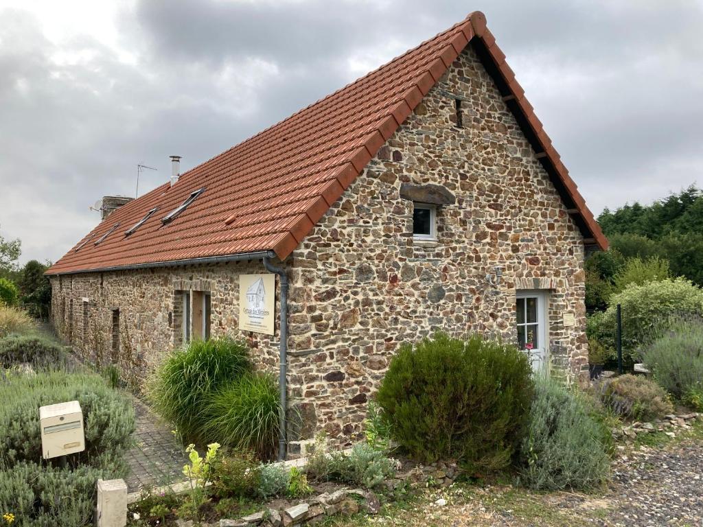 艾河畔圣日耳曼Cottage des Mézières的一座红色屋顶的古老石头建筑