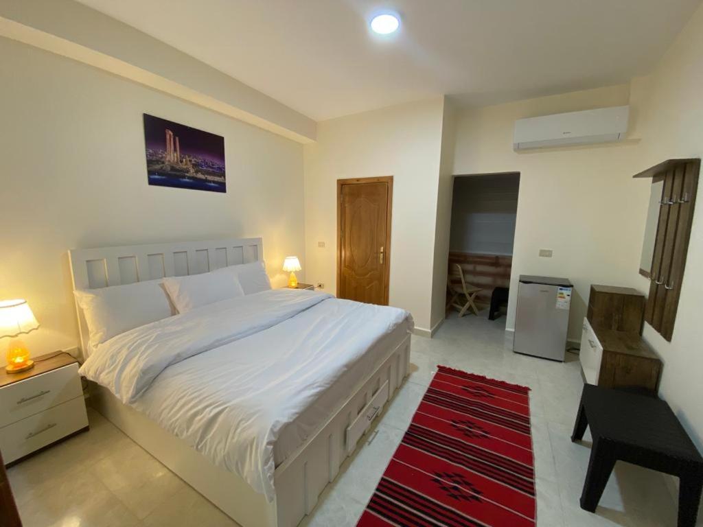 瓦迪穆萨Rose city inn的卧室配有白色的床和红色地毯。