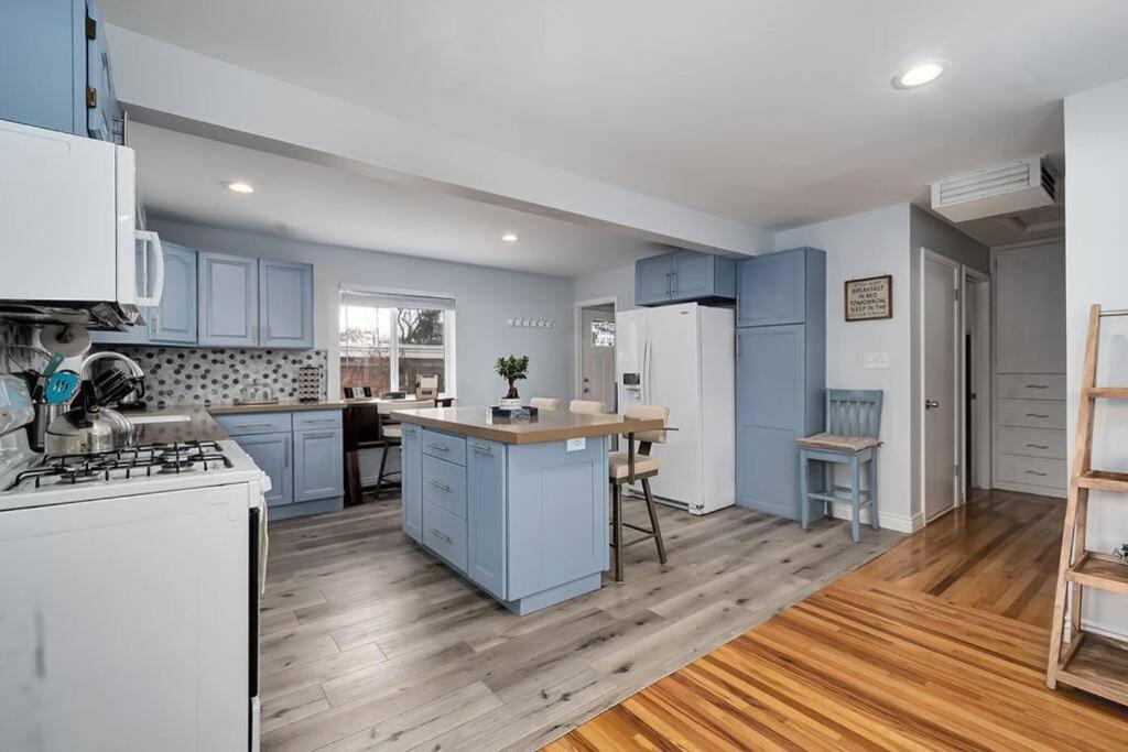 盐湖城Sugar House Urban Basecamp的一间铺有木地板的大厨房,配有蓝色的橱柜