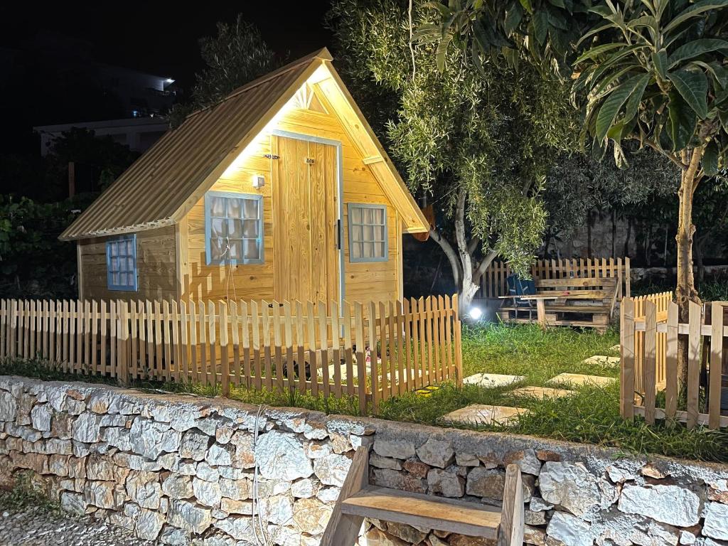 萨兰达Camping Albania-Secret Village Den的小屋设有围栏和长凳