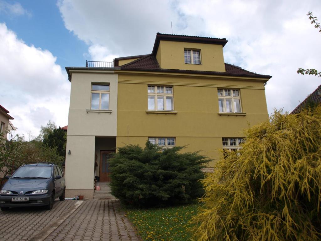 利托梅日采达利米尔卡公寓的一座黄色的房子,前面有一辆汽车