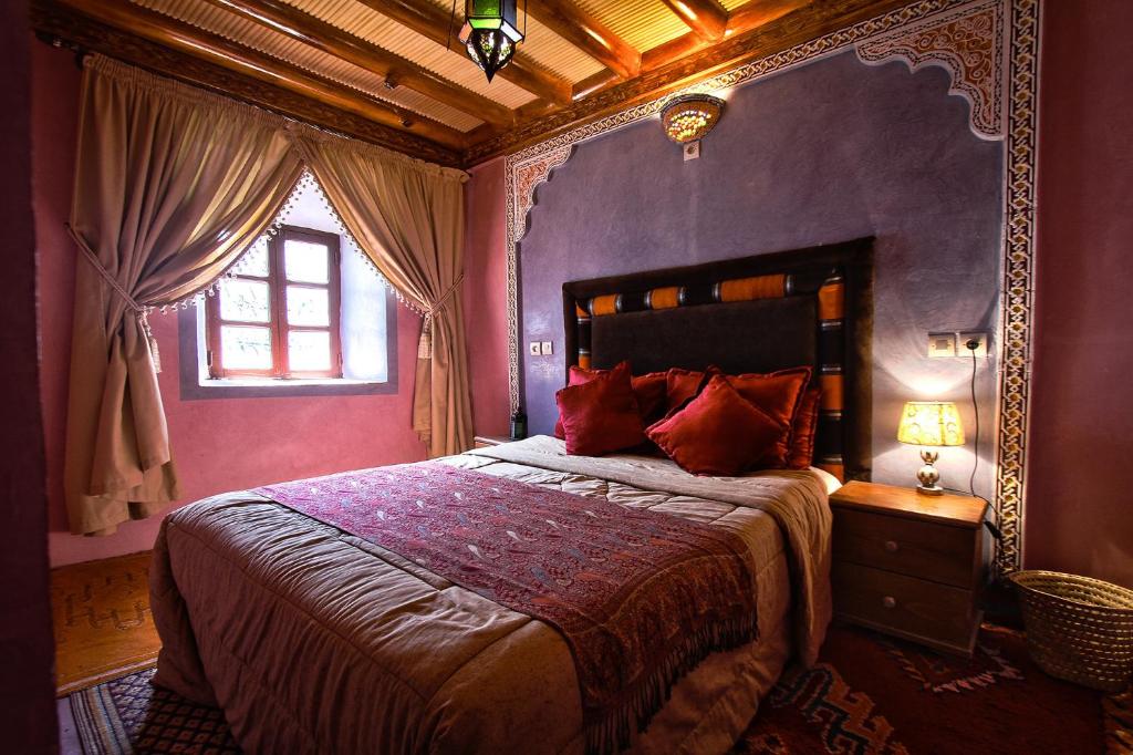 伊姆利尔阿特拉斯玛奇克乡间渡假别墅酒店的一间卧室配有一张紫色墙壁和窗户的床