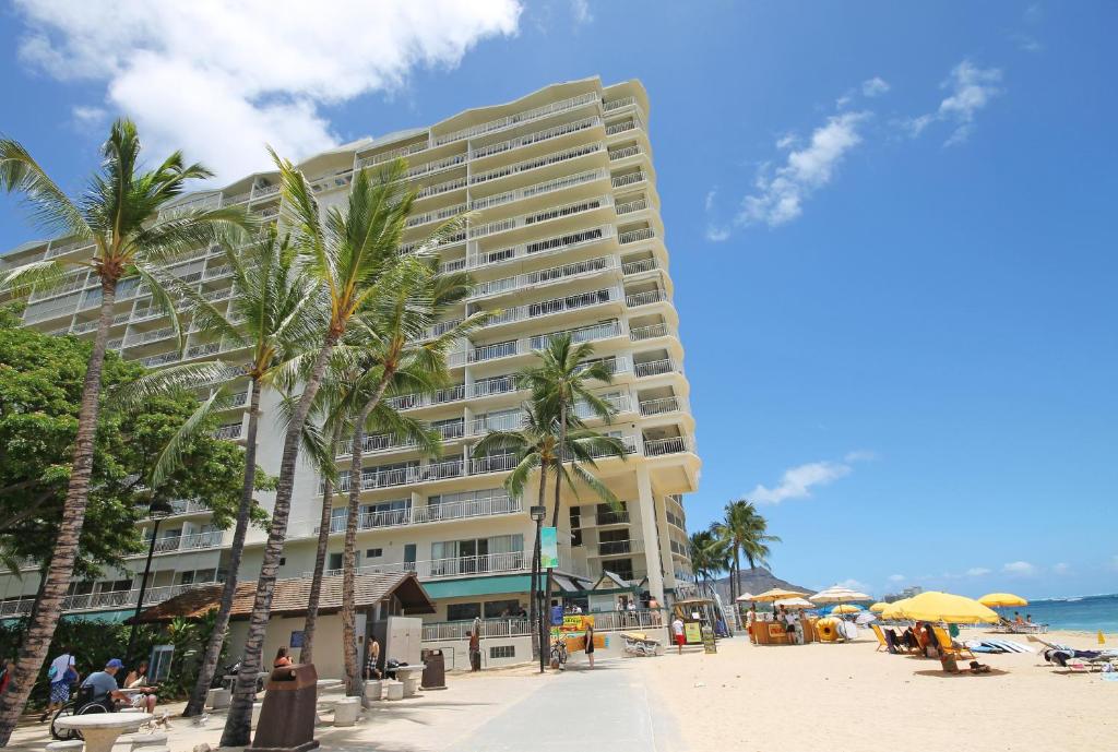 檀香山CASTLE Waikīkī Shores的棕榈树海滩上的一座大建筑