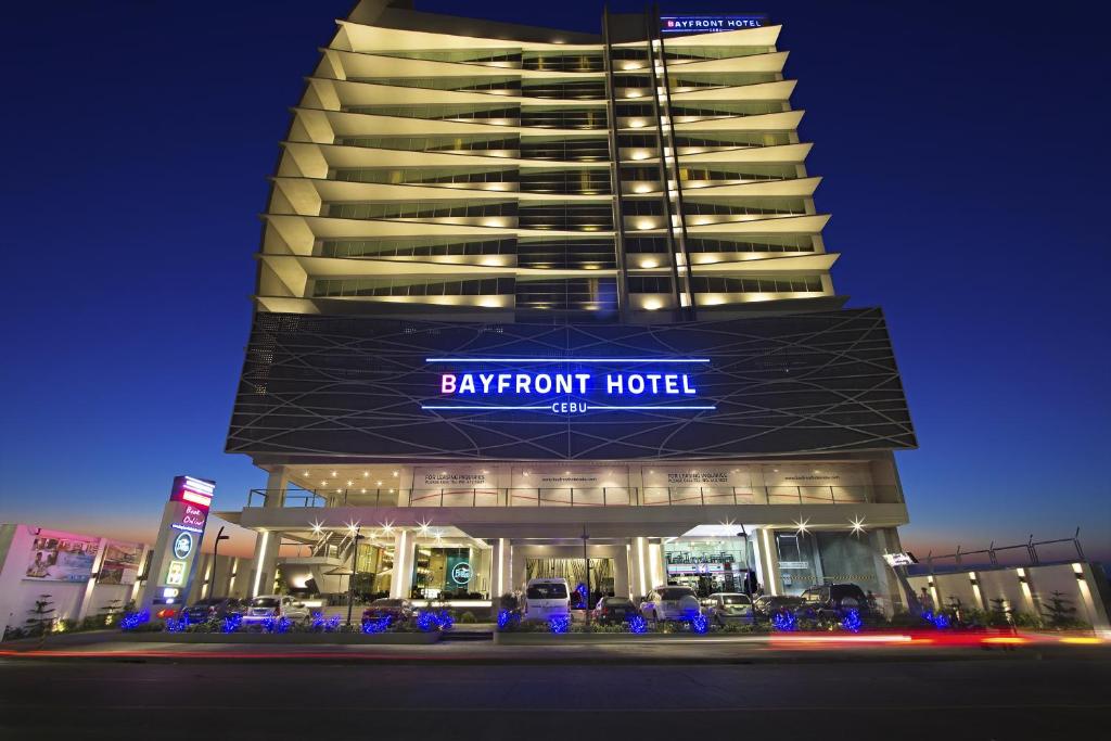 宿务Bayfront Hotel Cebu North Reclamation的一座大型酒店大楼,晚上有标志