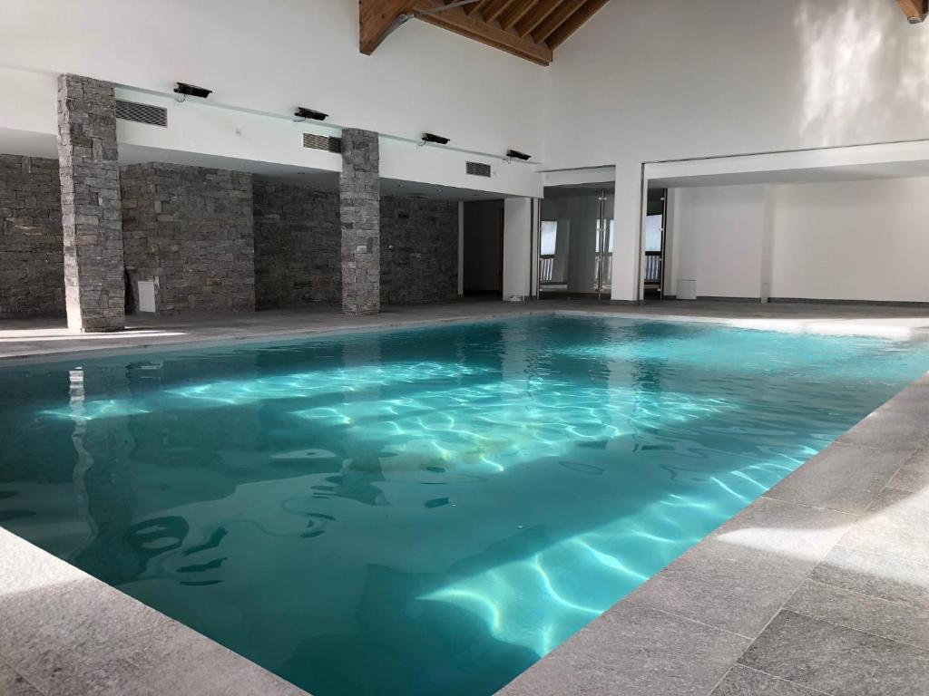 瓦尔residence avec piscine ,chalet des rennes的大楼内一个蓝色的大型游泳池
