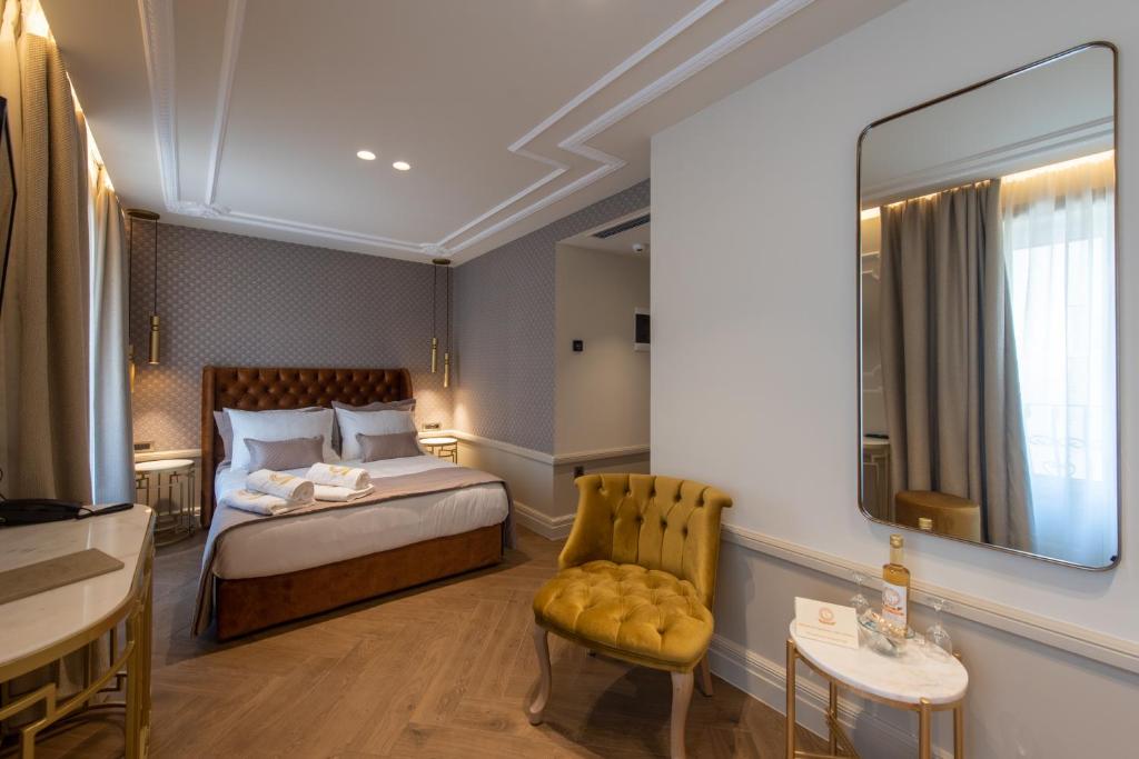 扎金索斯镇Capolavoro Suites的酒店客房,配有床、椅子和镜子
