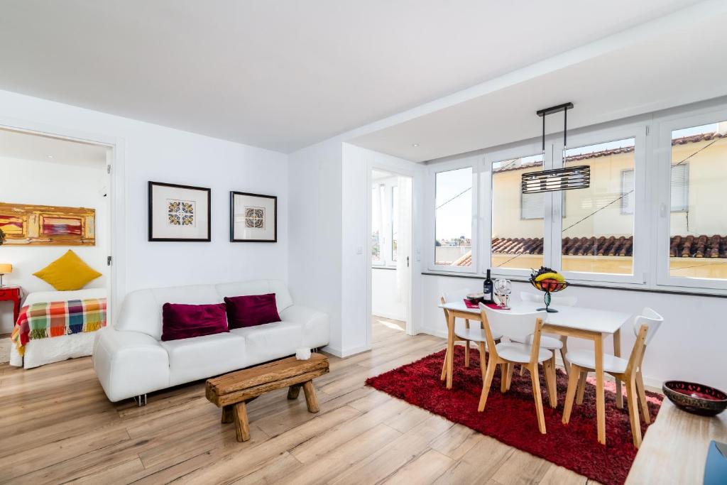 埃斯托利尔T2 Tiles Apartment Estoril的客厅配有白色的沙发和桌子