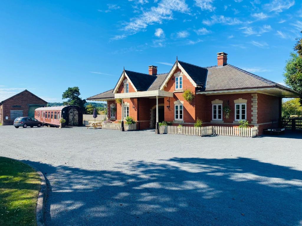 赫里福德The Booking Office, Stoke Edith Station的车道上停放汽车的砖房