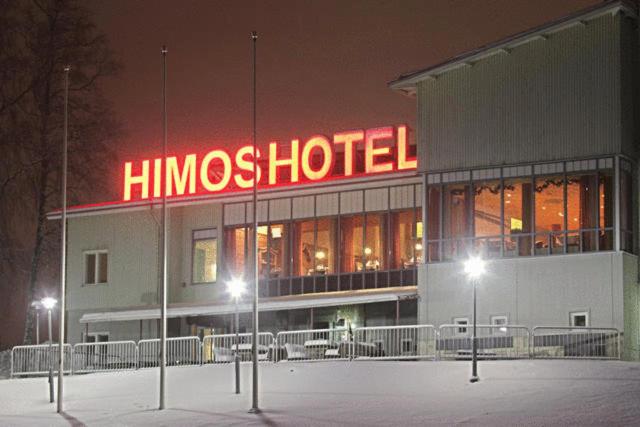 耶姆赛希莫斯酒店的夜间带有 ⁇ 虹灯标志的豪华酒店大楼