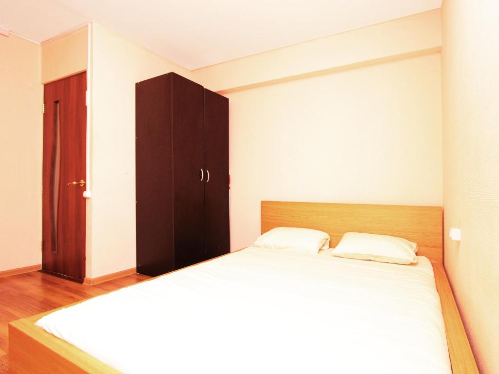 莫斯科乐克诺豪华公寓的一间卧室配有一张大床和一个棕色的橱柜