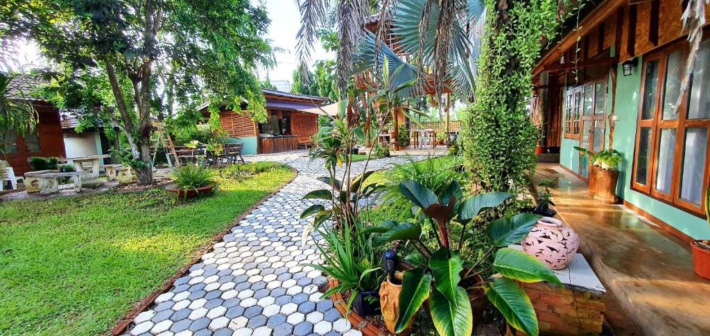 清莱Baan Suan Taboon Homestay的种植了植物的花园,建筑