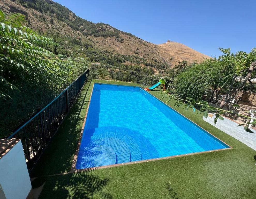 卡索拉Casa Rural La Fabrica De Nacelrio的山前的大型蓝色游泳池