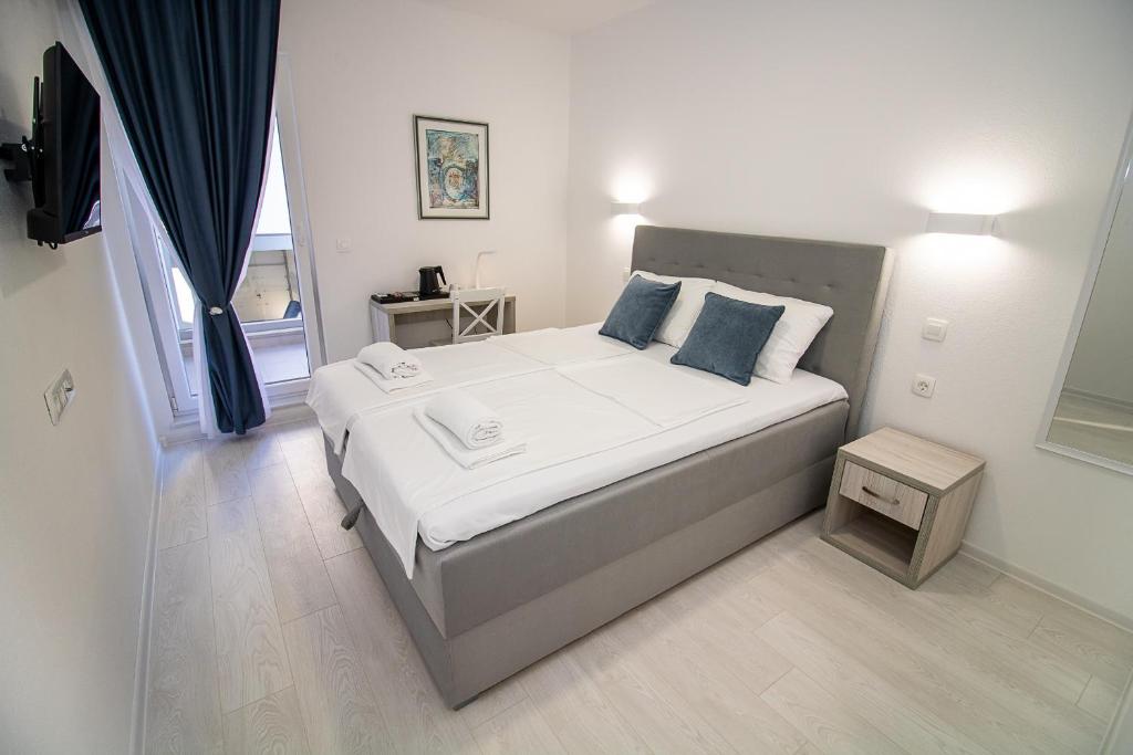 莫斯塔尔Villa Sonata的一间卧室配有带白色床单和蓝色枕头的床。