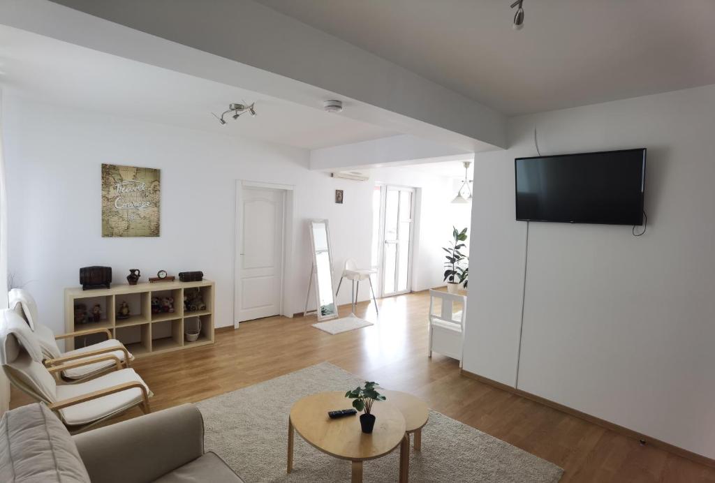 拉姆尼库沃尔恰Casa Reds的客厅配有沙发和墙上的电视