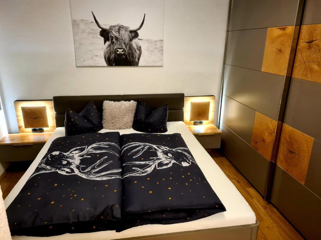 RifenalALPTyrol的卧室配有一张床,墙上挂着一只公牛