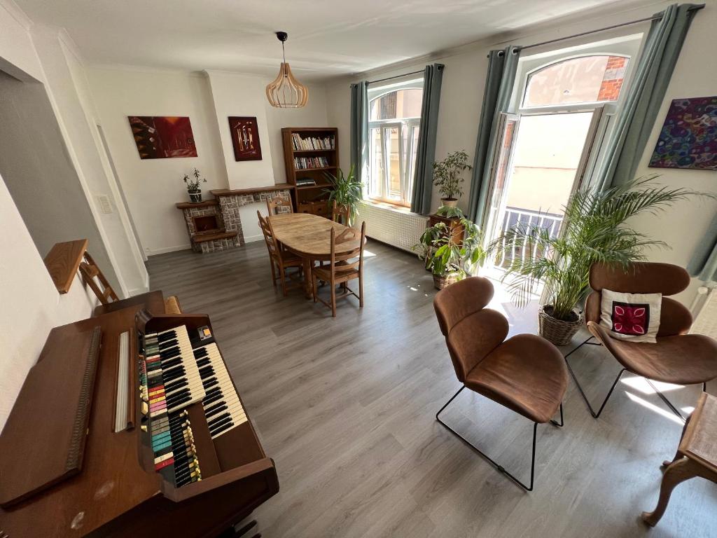 迪南Relax Sax Appartment的客厅配有钢琴、桌子和椅子