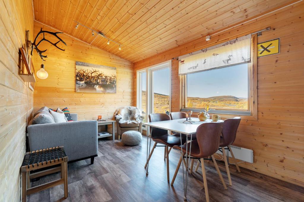 KjøllefjordDavvi Siida - Reindeer Design Lodge的配有桌椅和沙发的房间