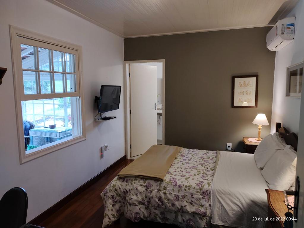 伊塔蒂亚亚Rancho São Carlos的一间卧室设有一张床和一个窗口