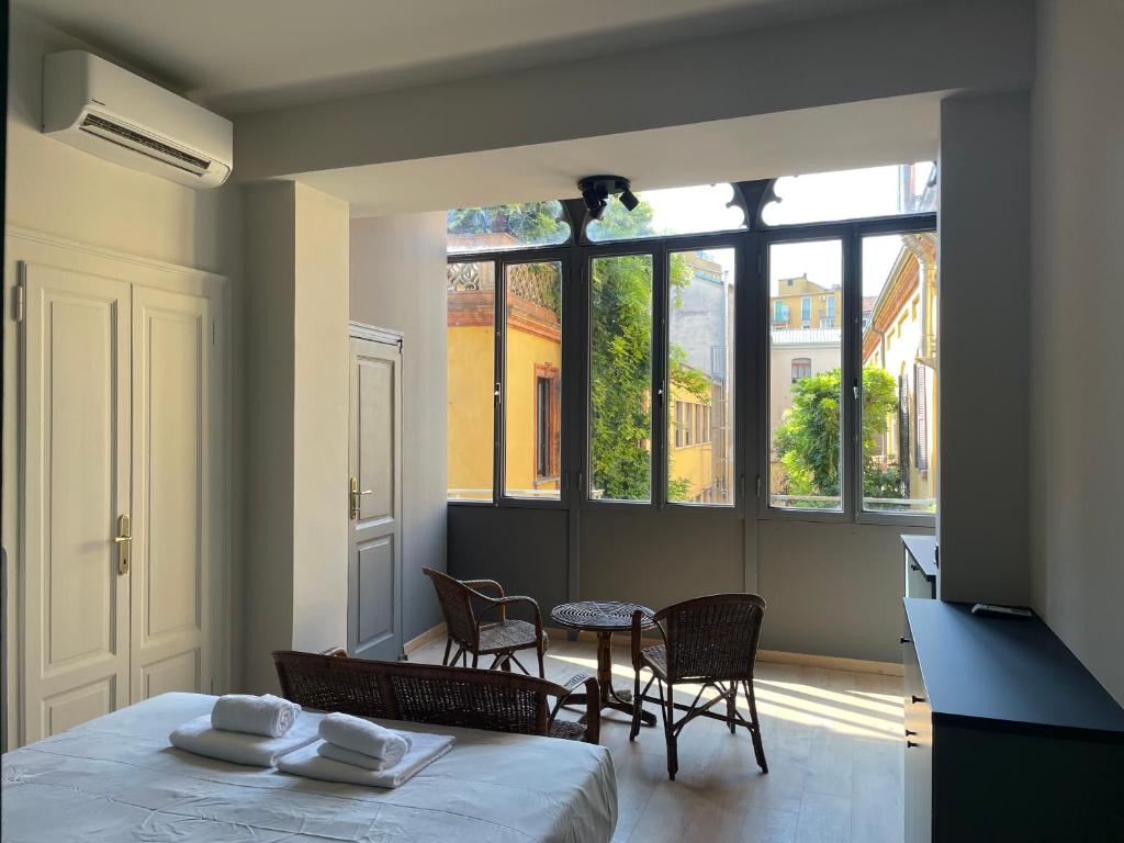 米兰Ritorno alle origini Suites的配有一张床和一张桌子及椅子的房间