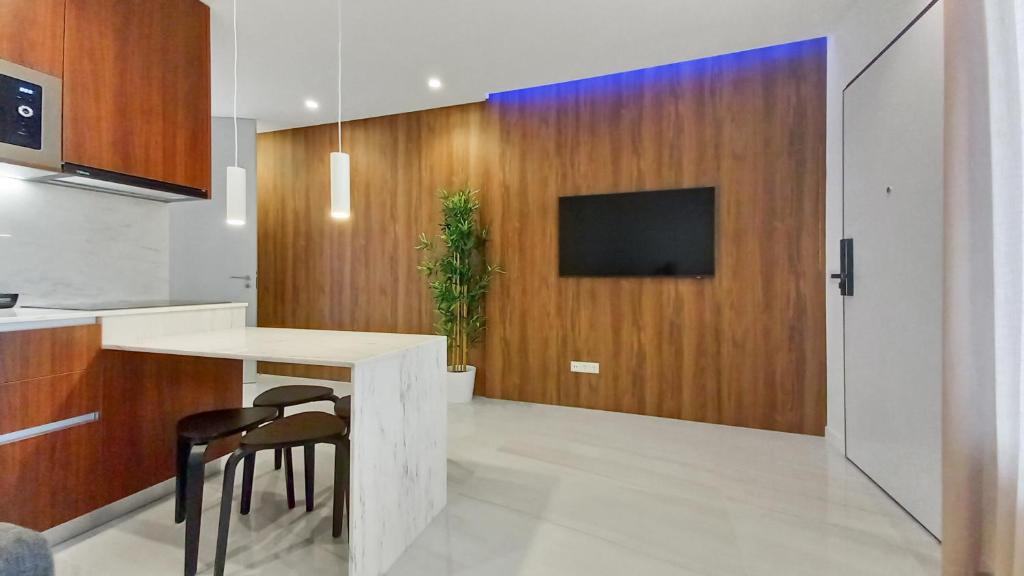 纳扎雷Seven Seas Apartments的厨房配有桌子,木墙上配有电视。