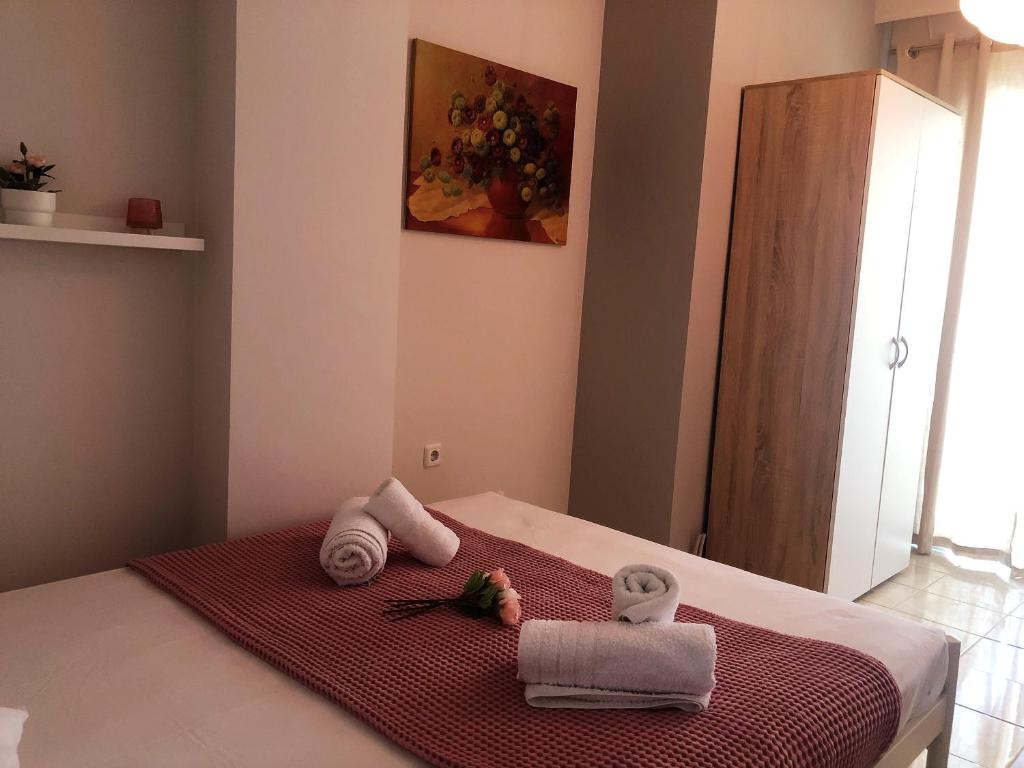 尼亚普拉莫斯Pink Rose Apartment的一间卧室配有带毛巾的床