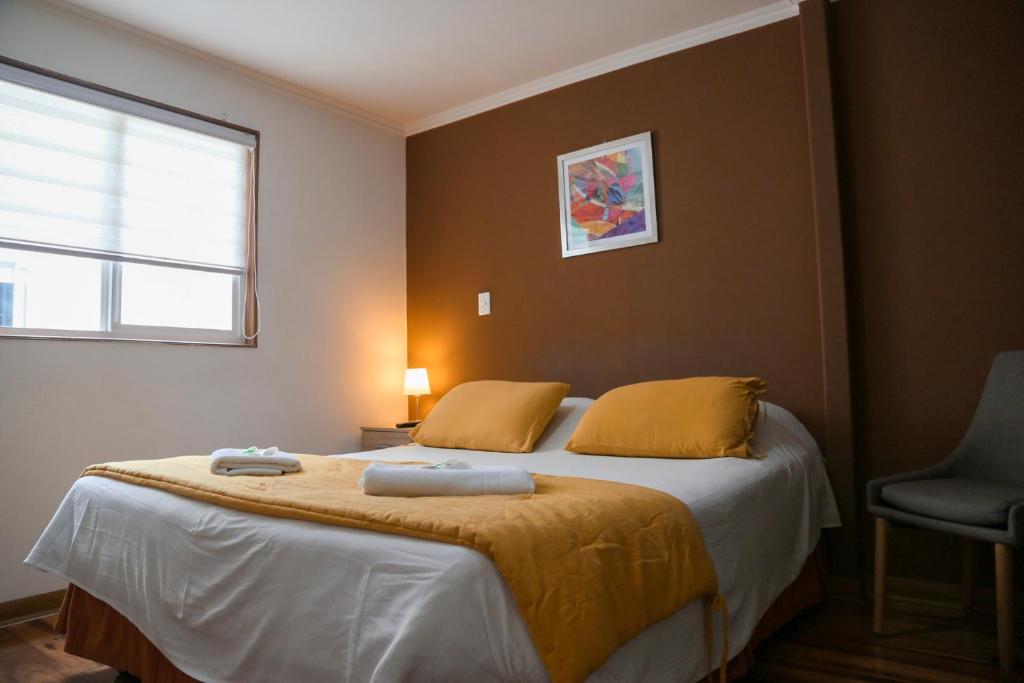 安托法加斯塔Aparthotel Don Alonso的一间卧室配有一张床,上面有两条毛巾