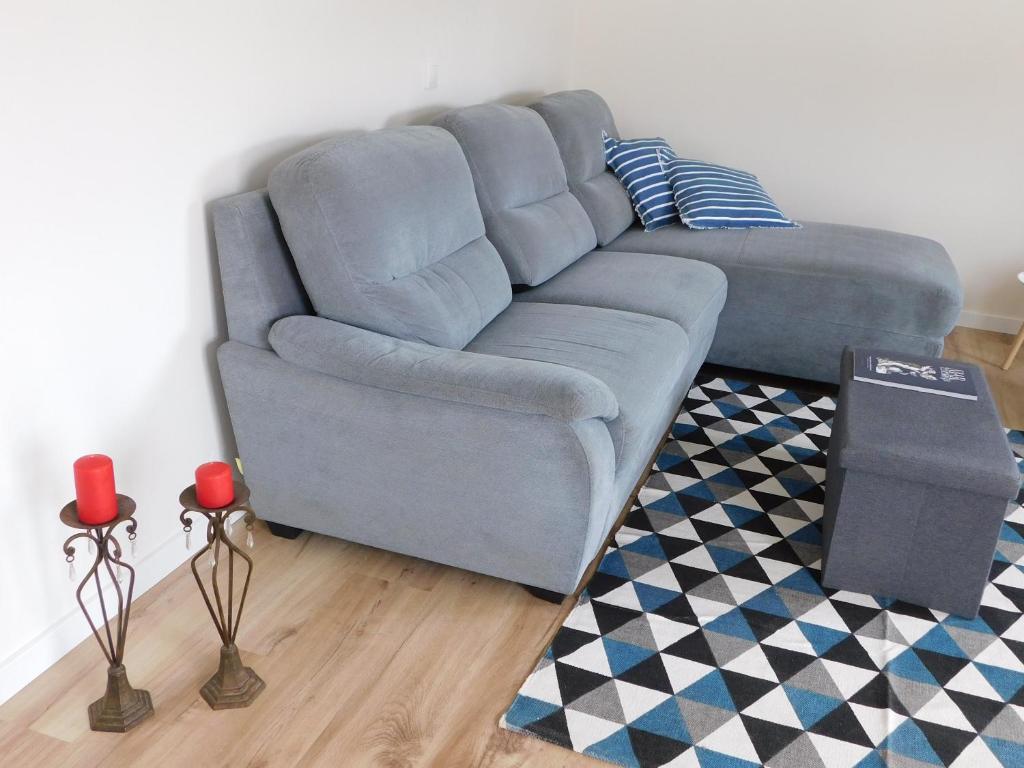 奥尔塔NiaAzoreanApartments2, aconchegante e confortável!的客厅里一张蓝色的沙发,铺着地毯