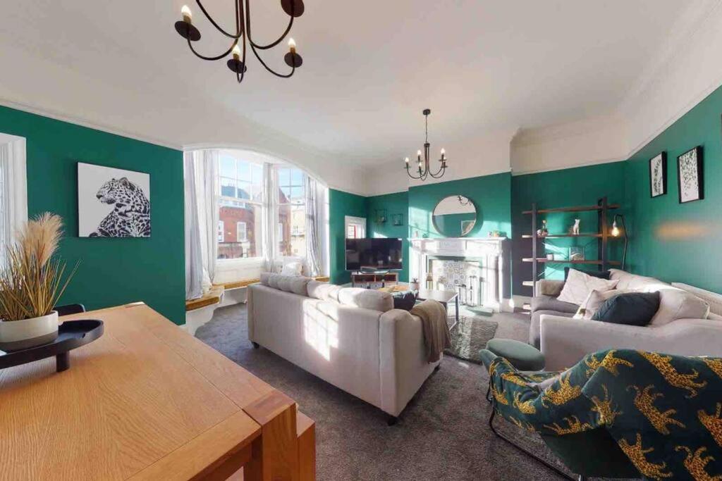 斯卡伯勒No.10 Seaside Apartment - 1st & 2nd Floor的客厅设有绿色墙壁和白色家具。