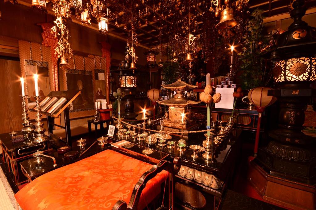 高野山高野山 宿坊 宝城院 -Koyasan Shukubo Hojoin-的一间设有桌子、钢琴和灯的房间