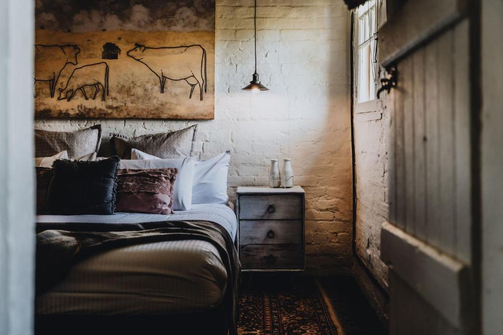 卡斯尔梅恩The Dairy的卧室配有一张床,墙上挂有绘画作品