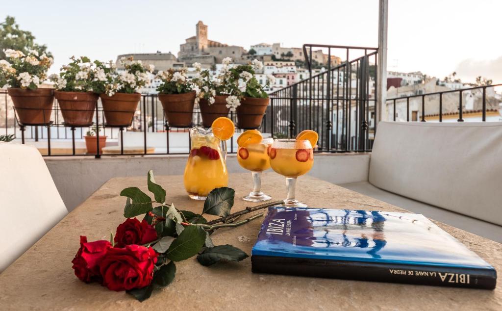 伊维萨镇马里亚诺公寓酒店的阳台上的桌子和两杯眼镜及一本书