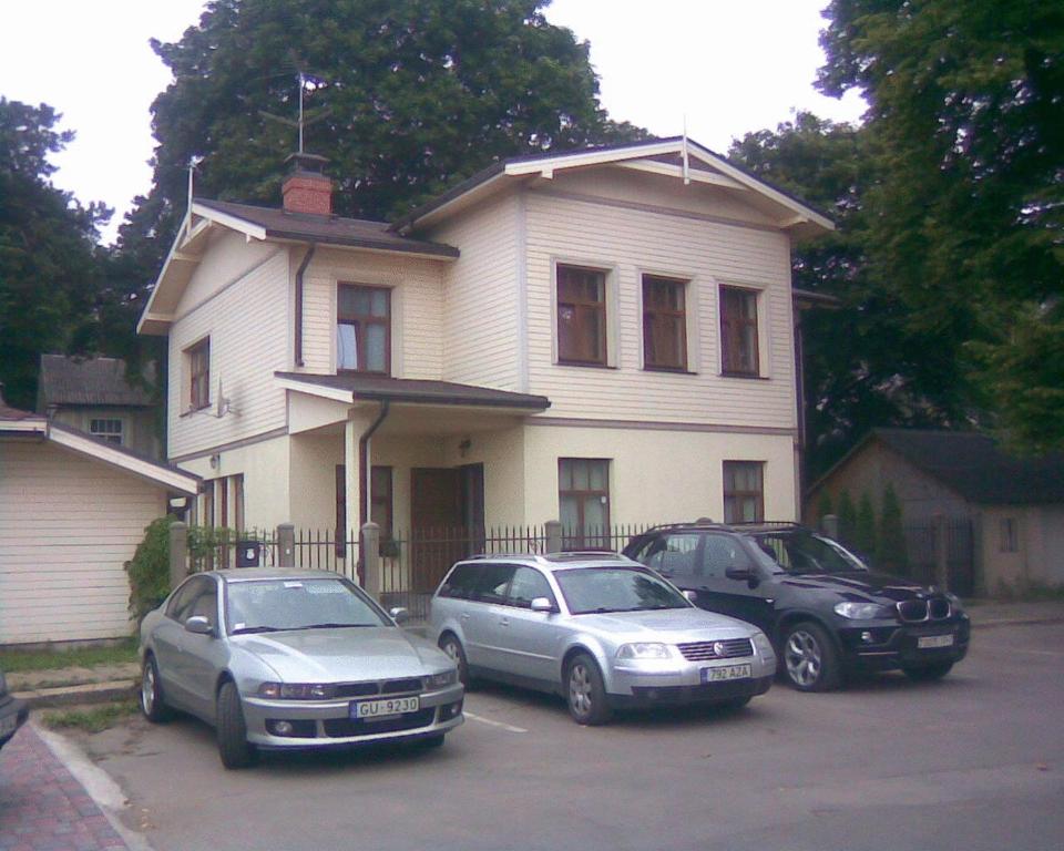 尤尔马拉捷马斯24旅馆的三辆车停在房子前面的停车场