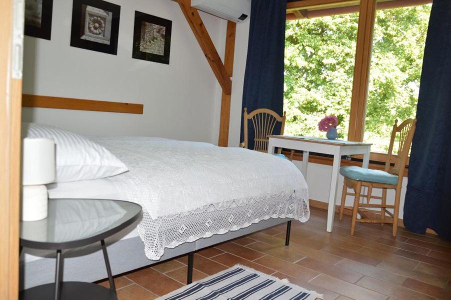 GradacNad Lahinjo的一间卧室配有一张床、一张桌子和一个窗户。