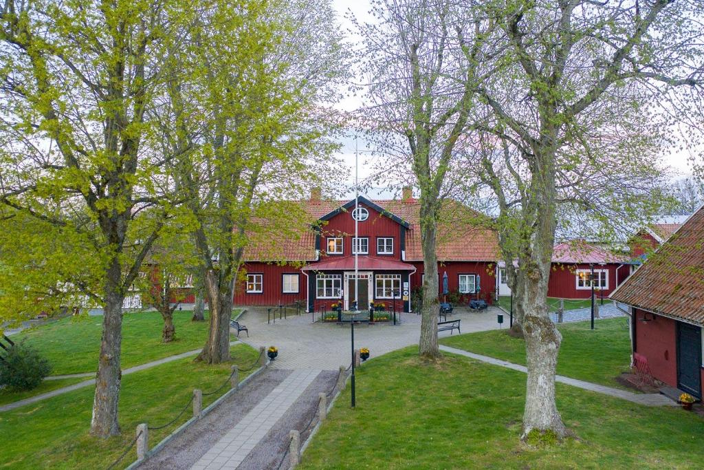 Söderåkra斯图芬娜丝加斯吉福里酒店的一座红色的大建筑,前面有树木