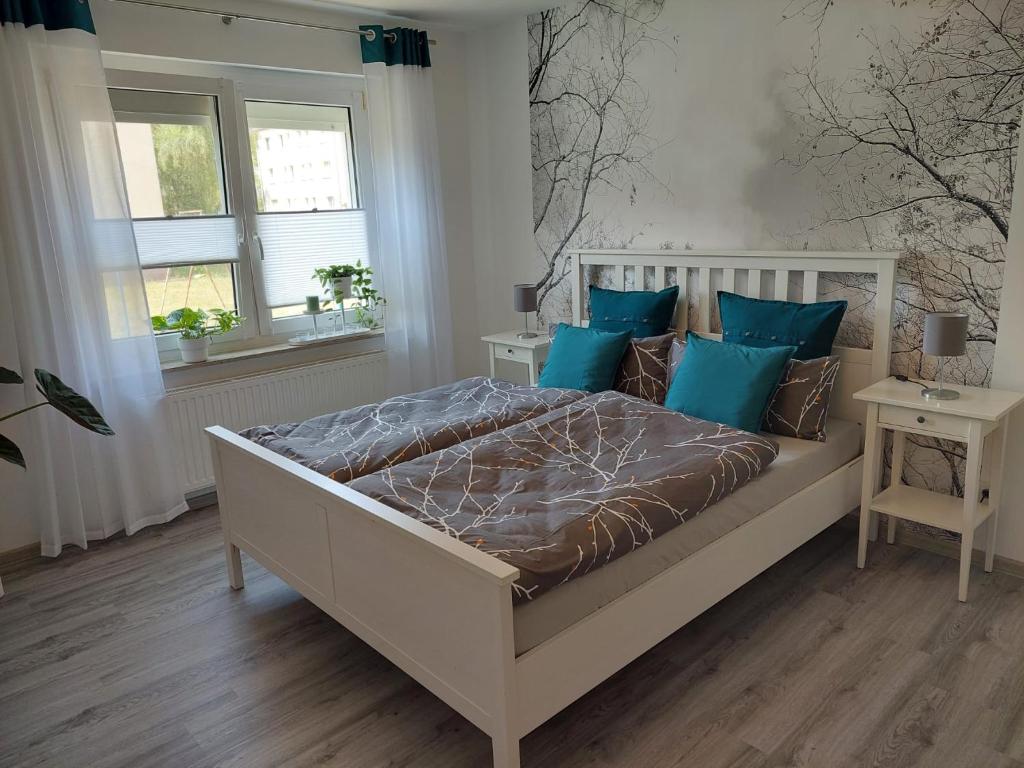 萨勒河畔哈雷Gemütliches, voll ausgestattetes Apartment的一间卧室配有一张带蓝色枕头的大床