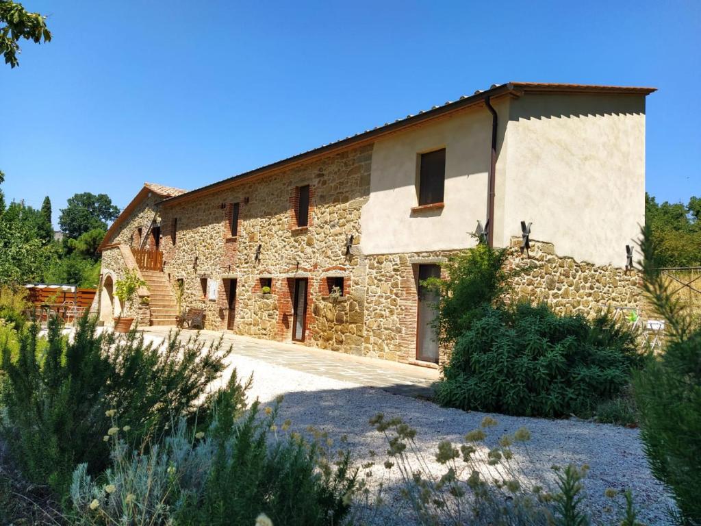 特拉西梅诺湖畔托罗Agriturismo L'Accolta的一座古老的石头建筑,前面有车道