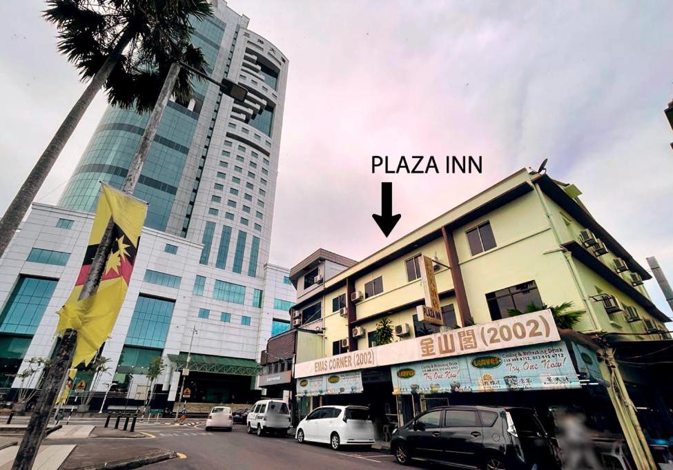 诗巫Plaza Inn的一条城市街道,汽车停在建筑前