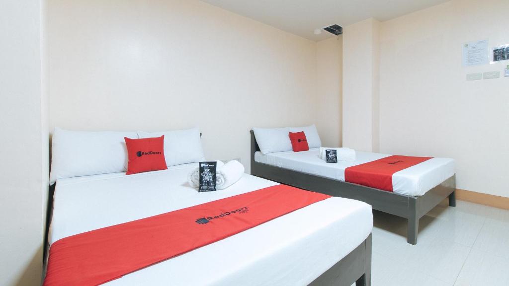 土格加劳RedDoorz Isabelita Hotel Tugegarao City的红色和白色的客房内的两张床