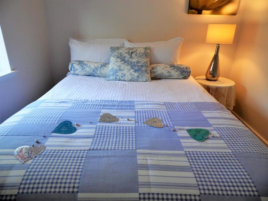 格拉斯哥Signature - Campsie Cottage的床上有蓝色和白色的被子