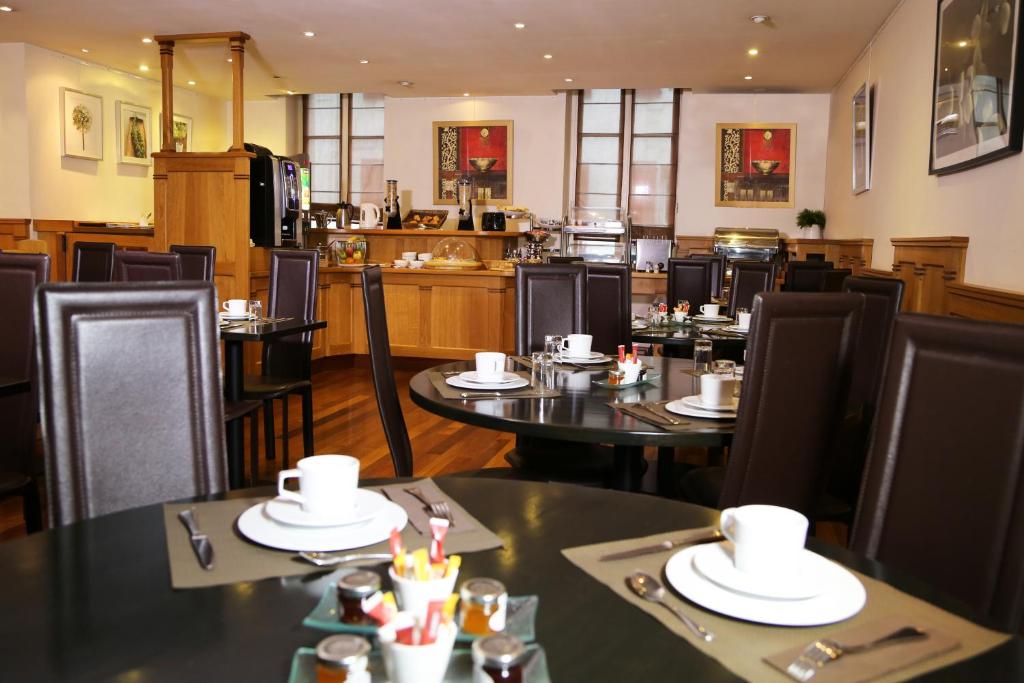 圣让-德吕兹科尔伯特酒店的一间带桌椅的餐厅和一间厨房