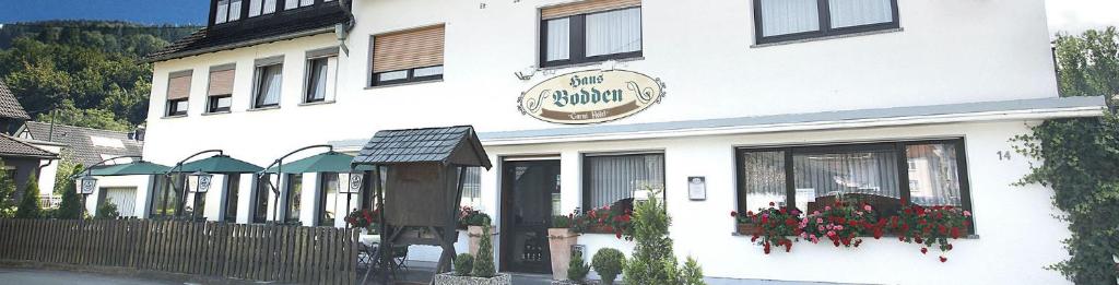 古梅尔斯巴赫Garni Hotel Bodden的白色的建筑,前面有标志