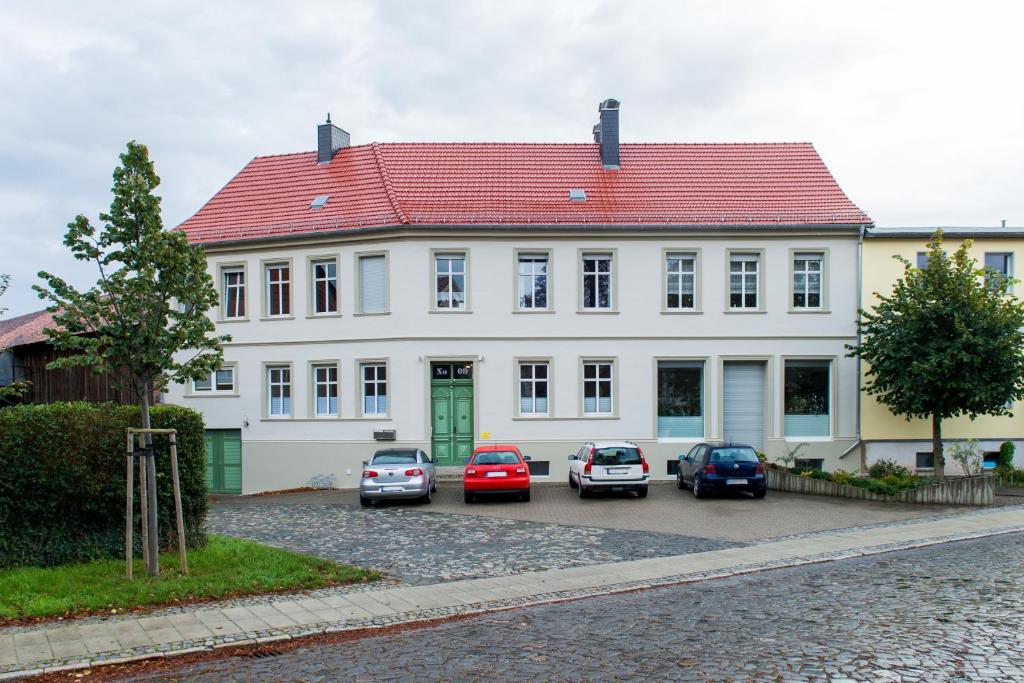 阿舍尔斯莱本Apartment im Harz的一座白色的房子,前面有汽车停放