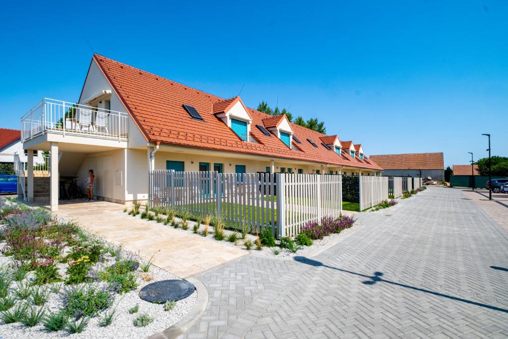 雷德尼斯Apartmány Na Zahradách的一座带橙色屋顶和白色围栏的房子