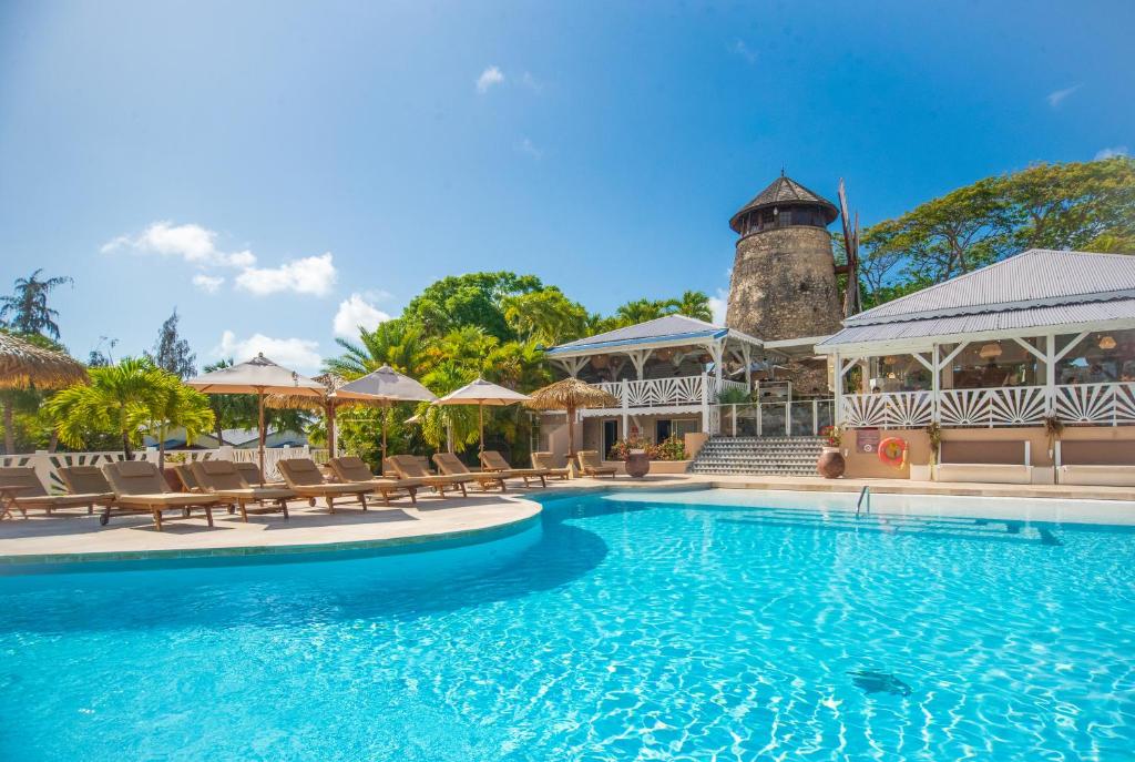圣安尼Le Relais du Moulin - Hôtel de Charme & Spa Adult Only的一个带椅子和灯塔的度假村游泳池